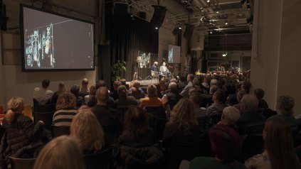 Oluf Borbye Pedersen i samtale med Lars Igum Rasmussen. Simultantegnet af Tea Bendix, musik Anders Hjernø 