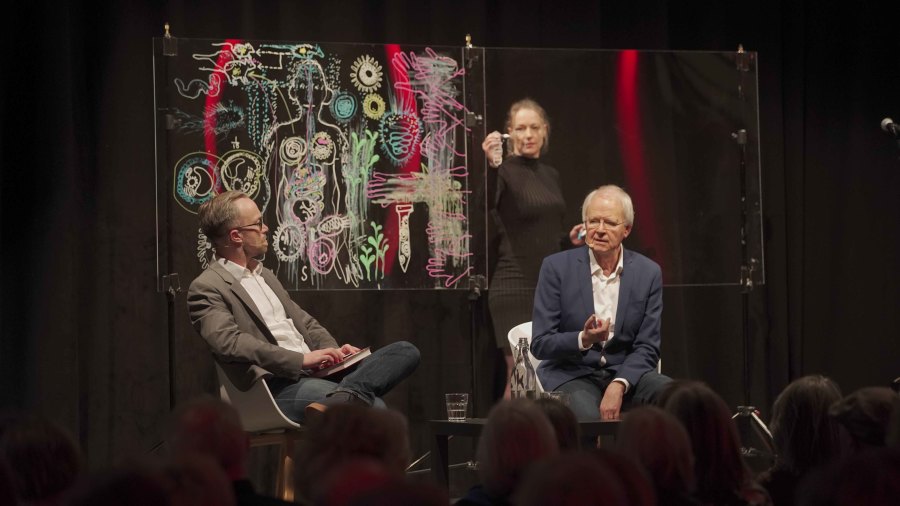 Oluf Borbye Pedersen i samtale med Lars Igum Rasmussen. Simultantegnet af Tea Bendix, musik Anders Hjernø